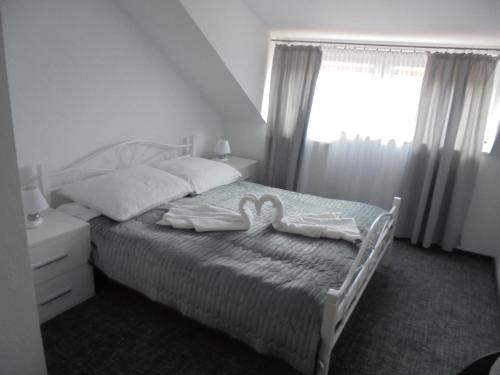 a bedroom with a bed with two towels on it at Villa Sovita in Łeba