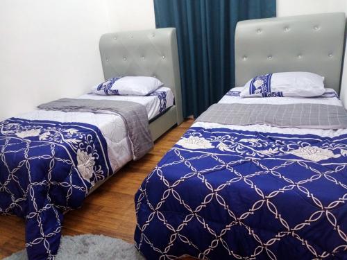 two beds sitting next to each other in a room at CASARIA HOMESTAY PD 3Bedrooms Bungalow House in Port Dickson