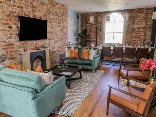 a living room with furniture and a brick wall at Guisborough Town Hall in Guisborough