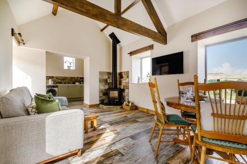 ein Wohnzimmer mit einer Couch und einem Tisch und Stühlen in der Unterkunft Foxglove in Whitby