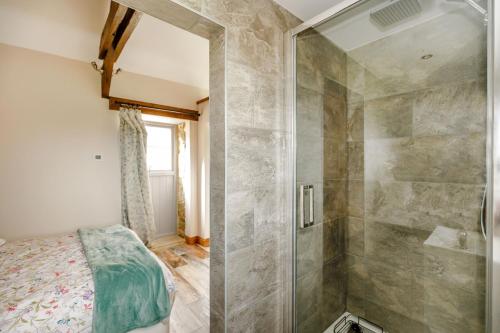 a bathroom with a shower and a bed in a room at Foxglove in Whitby