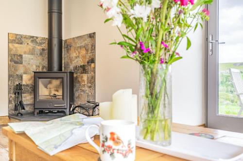 a vase of flowers on a table with a fireplace at Meadowsweet in Whitby