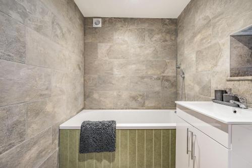 a bathroom with a bath tub and a sink at Meadowsweet in Whitby