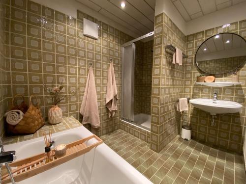 een badkamer met een bad en een wastafel bij Appartement Kollingwald in Saalfelden am Steinernen Meer