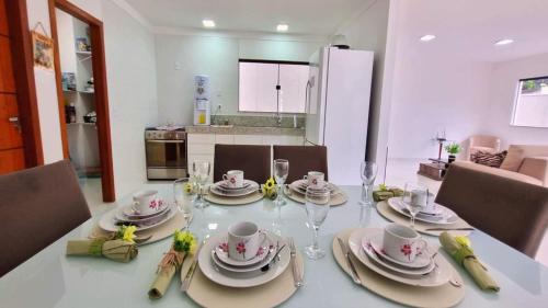 una mesa de comedor con platos y copas de vino en Casa com 3 suítes perto da Praia e do Centro de Porto Seguro, en Porto Seguro