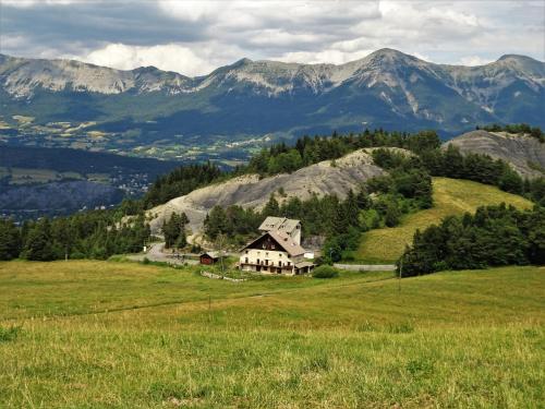 dom na wzgórzu z górami w tle w obiekcie Gite montagnard du Fanget w mieście Auzet