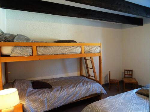 two bunk beds in a room with a bed at Gite montagnard du Fanget in Auzet