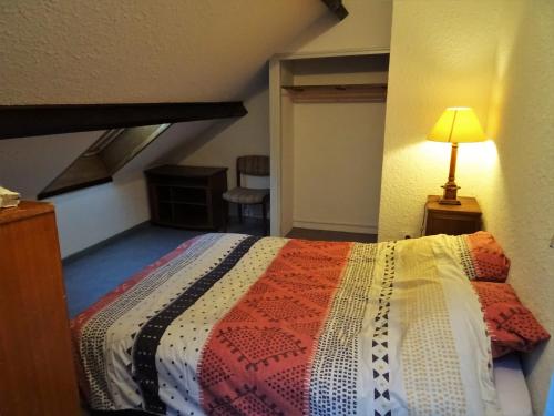 a bedroom with a bed with a colorful quilt at Gite montagnard du Fanget in Auzet