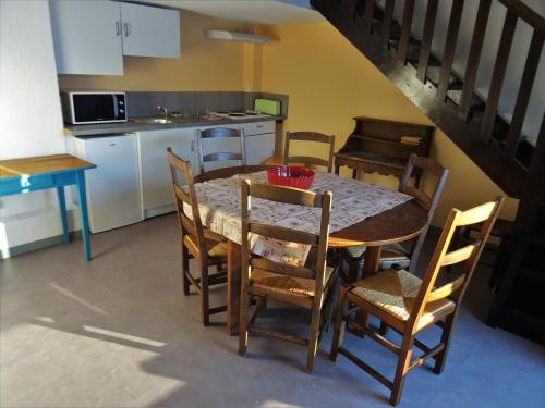 a kitchen with a table and chairs and a kitchen with a staircase at Gite montagnard du Fanget in Auzet