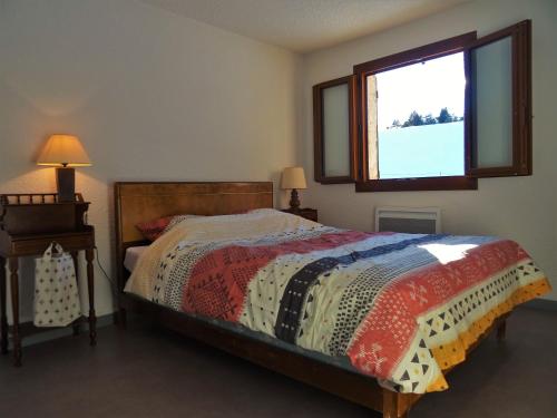 a bedroom with a bed and a window at Gite montagnard du Fanget in Auzet