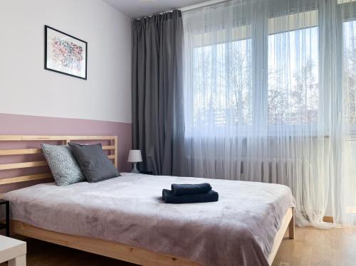 a bedroom with a bed and a large window at Shape&Color premium Hostel in Warsaw