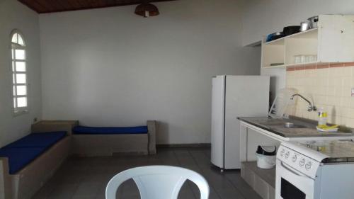 a kitchen with a white refrigerator and a white chair at Chalés 1 e 2 dormitórios - Juquehy in São Sebastião