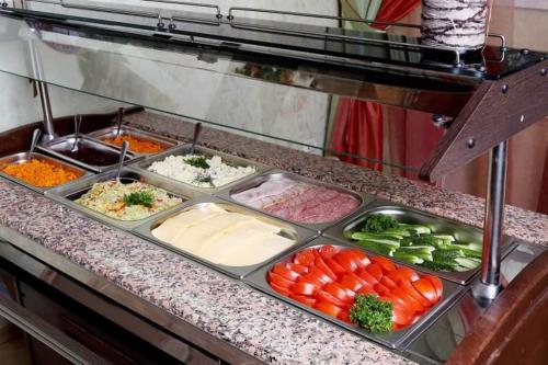a counter with several trays of different types of vegetables at Wave-ტალღა in Kobuleti