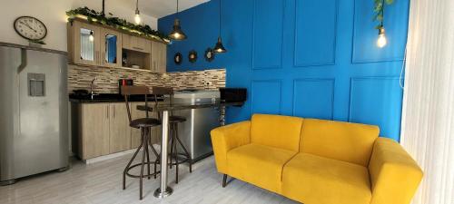 sala de estar con sofá amarillo y pared azul en Casa Azul, en Medellín
