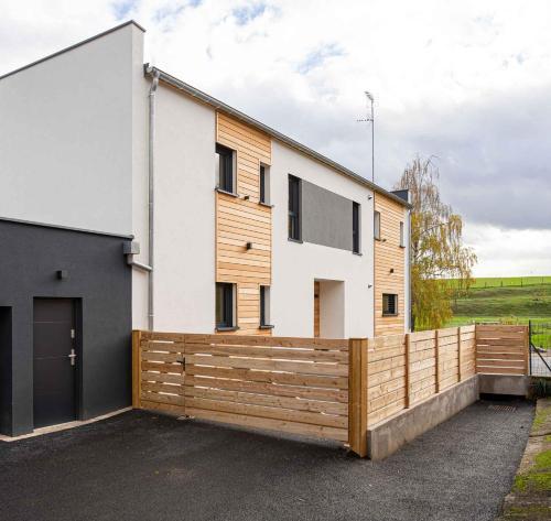 a house with a wooden fence in front of it at La Maison Devant La Prairie de 4 à 40 personnes in Griesheim-près-Molsheim