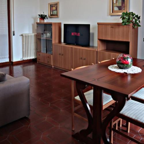 sala de estar con mesa y TV en Ampio appartamento a 5 minuti da Rho-fiera Milano, en Cornaredo