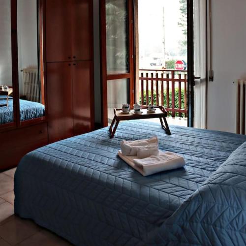 un letto blu con un vassoio sopra di Ampio appartamento a 5 minuti da Rho-fiera Milano a Cornaredo