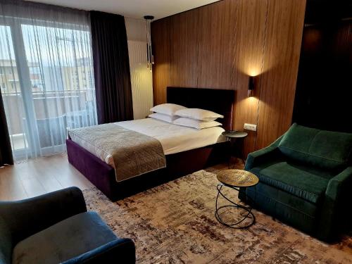 a hotel room with a bed and a chair at AMA by Melis in Braşov