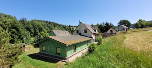 a small green house on a hill in a field at Altes Brauhaus Steinbach in Steinbach