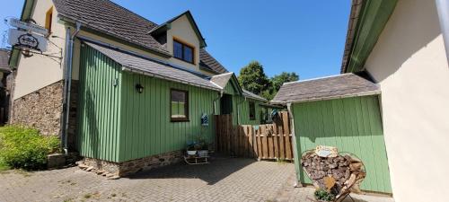 a row of green buildings in a courtyard at Altes Brauhaus Steinbach in Steinbach