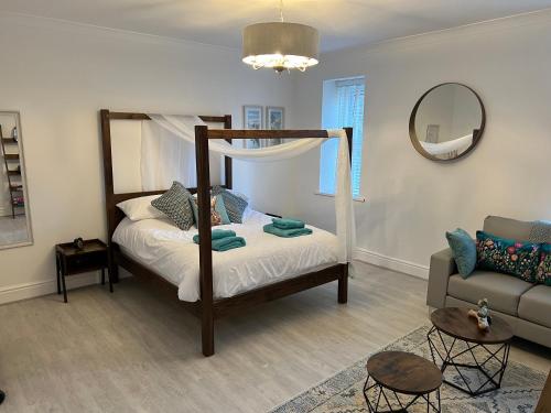 a bedroom with a canopy bed and a couch at Large Three bed Two bathroom flat in Central Torquay in Torquay