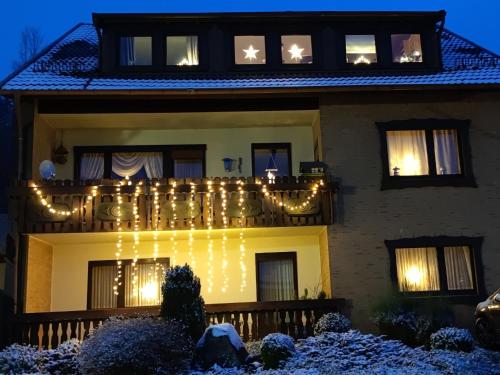 a house with christmas lights on the balcony at HarzLiebe in Herzberg am Harz