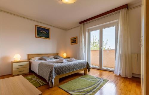 een slaapkamer met een bed en een groot raam bij Gorgeous Apartment In Medulin With Kitchen in Medulin