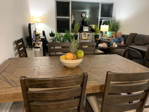 a dining room table with a bowl of fruit on it at Pearlridge Gardens and Tower Aiea, Hawaii 96701 in Aiea