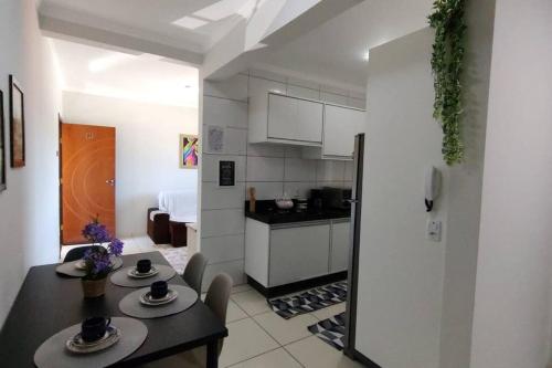 una cucina e una sala da pranzo con tavolo e sedie di Apartamento Doce Aconchego - RESIDENCIAL WAKI 05 a Dourados