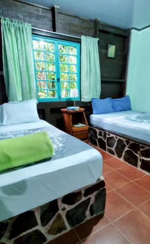 a room with two beds and a window at Cecropia Ecolodge in Fortuna