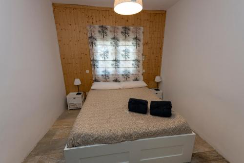 a small bedroom with a bed and a window at La Consentida in La Cabrera