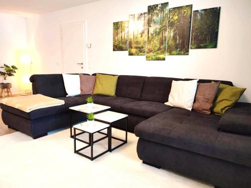 sala de estar con sofá marrón y mesa en Modern Mountain Apartment - free parking & sauna en Obertauern