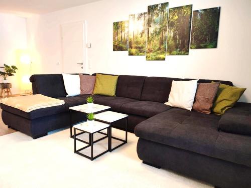 a living room with a brown couch and a table at Modern Mountain Apartment - free parking & sauna in Obertauern