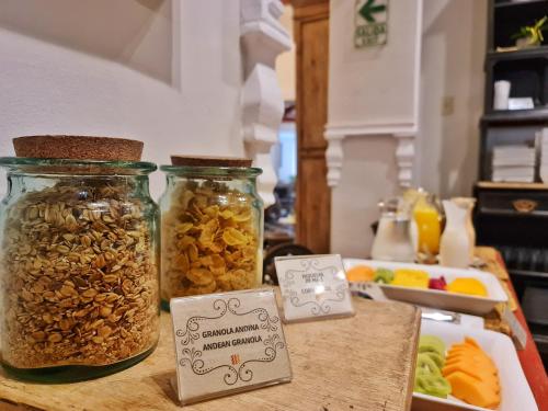 two jars of nuts on a table with a plate of food at Hotel Antigua Miraflores in Lima
