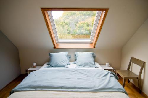 Un dormitorio con una cama y una ventana encima. en Vakantiewoning L'Eau Tendre in Ellezelles, met wellness, buitenzwembad en paardenstalling en Ellezelles