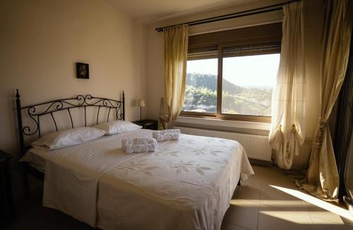 ein Schlafzimmer mit einem weißen Bett mit einem Fenster in der Unterkunft Villa Destiny in Pefkohori