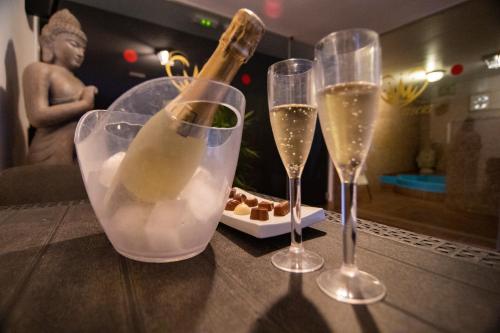 three wine glasses and a bottle of champagne on a table at Hotel El Tejar & Spa in Vilaflor