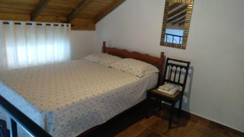 Un dormitorio con una cama y un teléfono en una mesa. en LOFT do Sonho!, en Palhoça