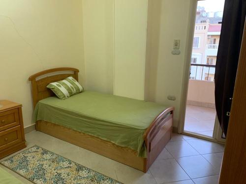um pequeno quarto com uma cama e uma janela em شقة سكنية ذات طابع عائلى متميز بها كافة الامكانيات من فلتر ماء وواى فاى em Hurghada