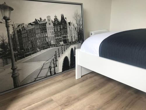 a bedroom with a bed and a picture of a bridge at Quiet Waterloft near Amsterdam and Schiphol WS17 in Aalsmeer