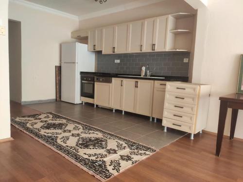 a kitchen with white cabinets and a rug on the floor at Alanya merkez Kleopatra plajinda in Alanya