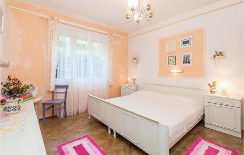a bedroom with a large white bed and a window at Beautiful Home In Palit With Kitchen in Rab