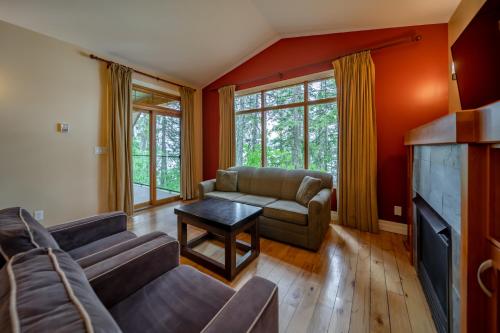 a living room with a couch and a tv at Halcyon Hot Springs Resort in Halcyon Hot Springs