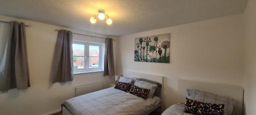 1 dormitorio con cama y ventana en Delightfully Decorated Home, Private Parking and Garden,Close to Abbey Wood and Woolwich Stations for Elizabeth Line Easy Access to Central London, West End,02,Greenwich Maritime Museum, en Thamesmead