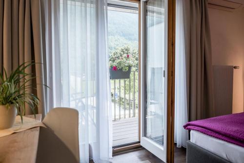 Cette chambre d'hôtel dispose d'un balcon avec une fenêtre. dans l'établissement Hotel Zur Traube, à Brigerbad