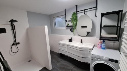 a bathroom with a sink and a washing machine at Spessartlounge in Mömbris