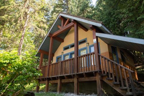 a cabin in the woods with a large deck at Halcyon Hot Springs Resort in Halcyon Hot Springs
