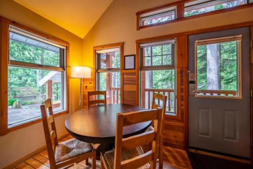 a dining room with a table and chairs and windows at Halcyon Hot Springs Resort in Halcyon Hot Springs