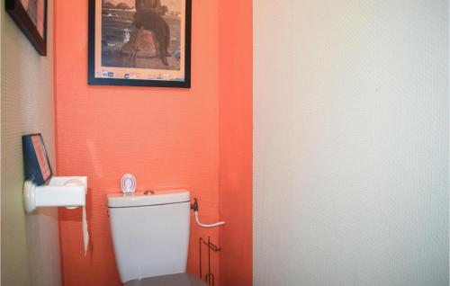 uma casa de banho laranja com um WC e uma fotografia na parede em Amazing Home In Lannion With Kitchenette em Lannion