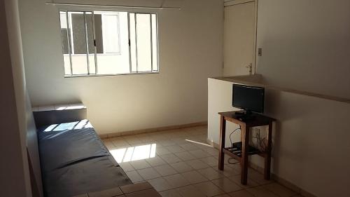 サンセバスチャンにあるChalés 1 e 2 dormitórios - Juquehyのベッド1台とテレビが備わる小さな客室です。